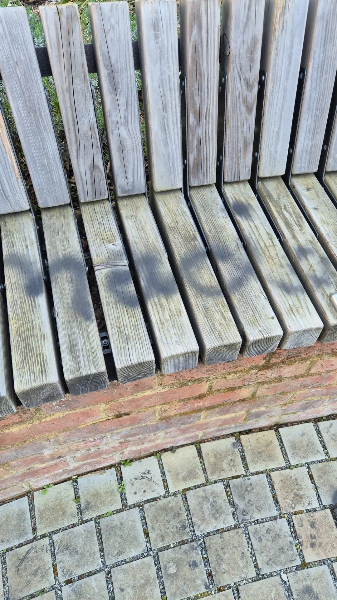 Wooden public bench restored after graffiti removal treatment