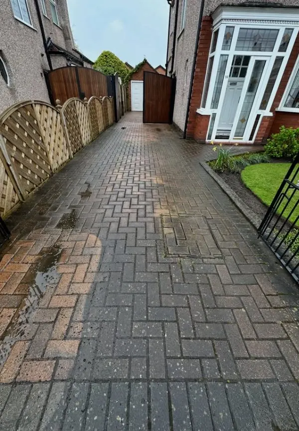 Dirty block paving driveway covered in moss and algae before professional pressure washing