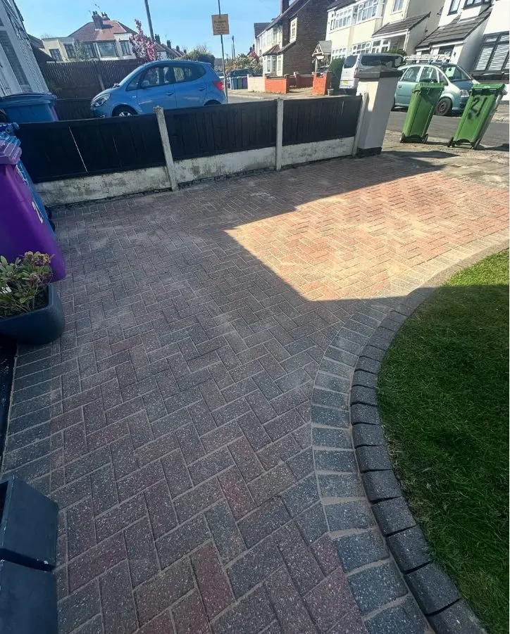 Professionally steam jet washed dark block paving driveway showing clean results