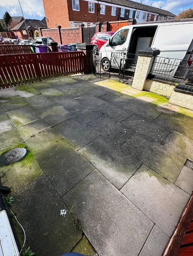 Dark algae-covered flagstone patio before professional patio cleaning