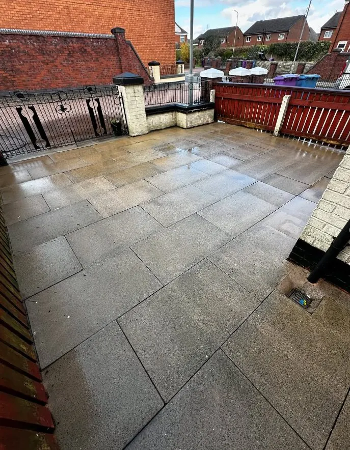 Clean grey flagstone patio after professional pressure washing restoration